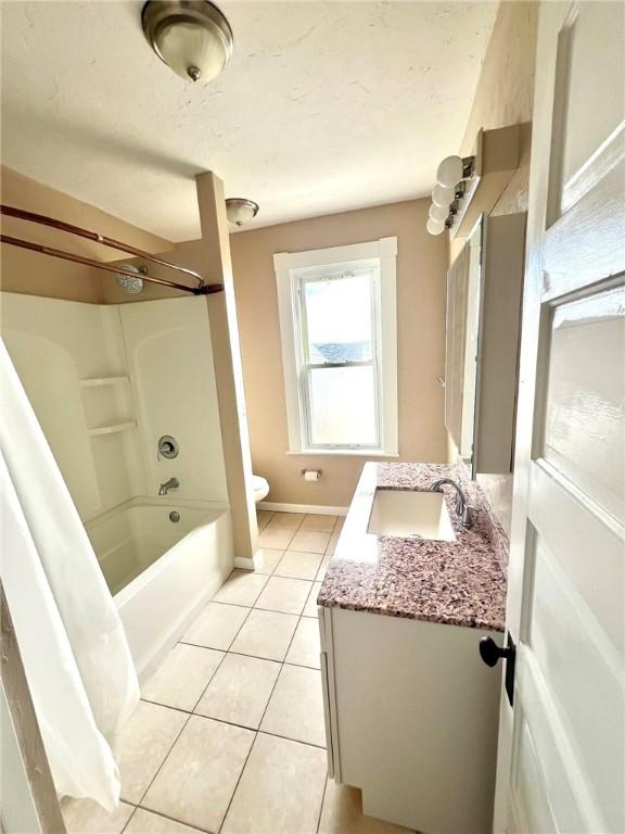 full bathroom featuring shower / bath combination with curtain, vanity, tile patterned floors, and toilet