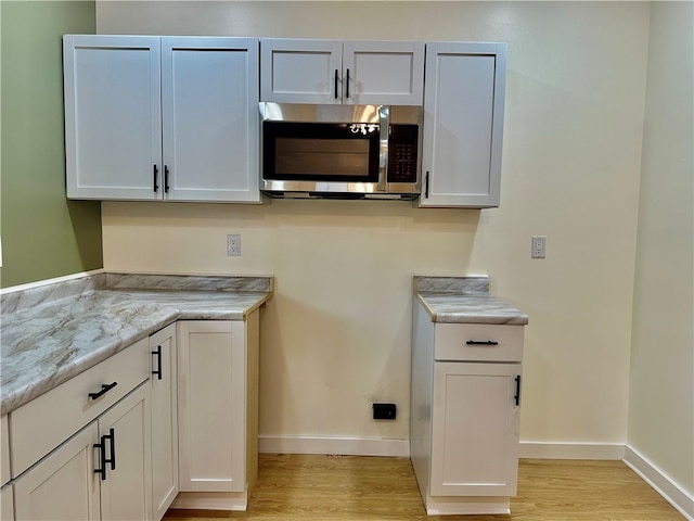 clothes washing area with light wood-type flooring