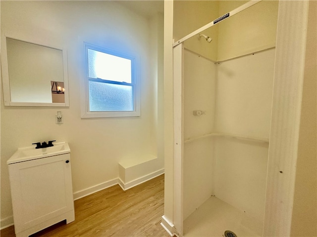 bathroom with walk in shower, toilet, sink, and hardwood / wood-style flooring