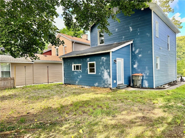 rear view of property featuring a lawn