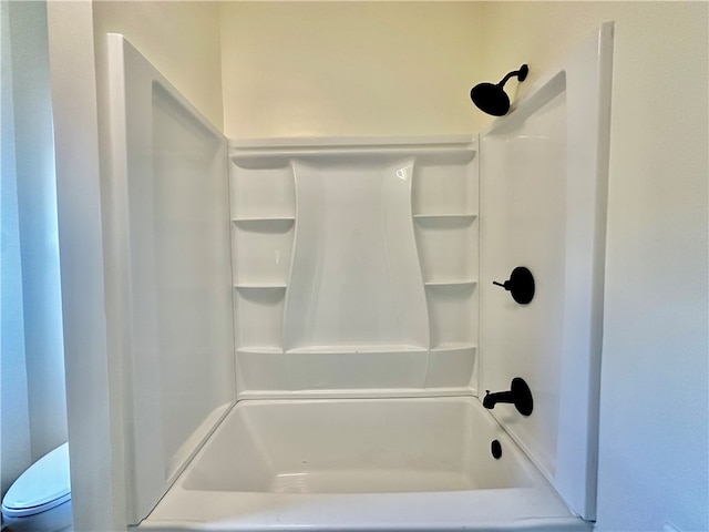 bathroom with bathtub / shower combination and toilet