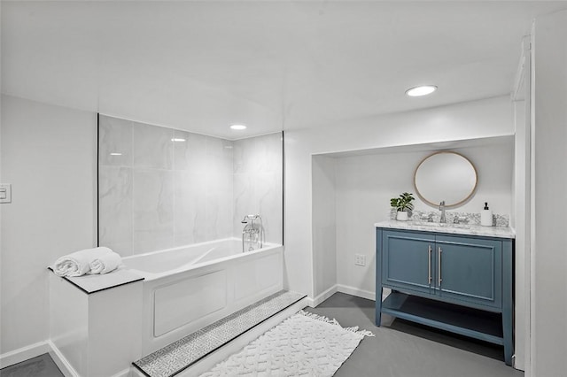 bathroom with vanity, concrete floors, and a bathtub