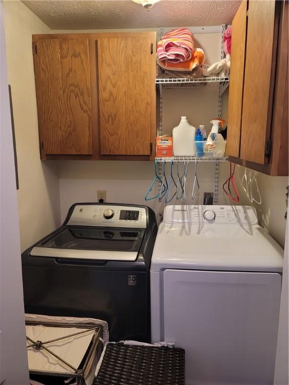 washroom with washer and dryer and cabinets