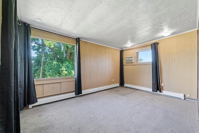 spare room with a baseboard heating unit, a wall mounted AC, a textured ceiling, and light carpet