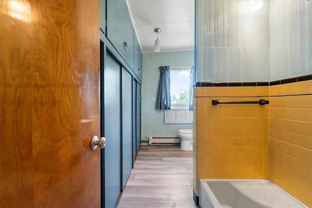 bathroom featuring toilet, tile walls, wood-type flooring, and a baseboard radiator