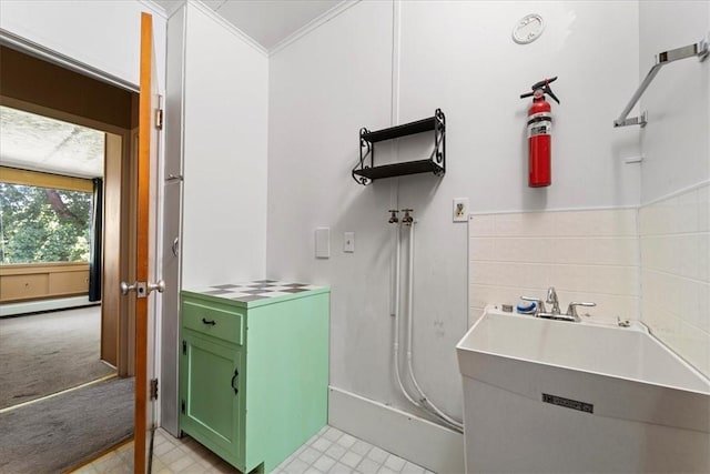 bathroom with crown molding, backsplash, a baseboard radiator, and sink