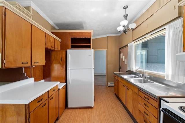 kitchen with white refrigerator, ornamental molding, hanging light fixtures, and sink