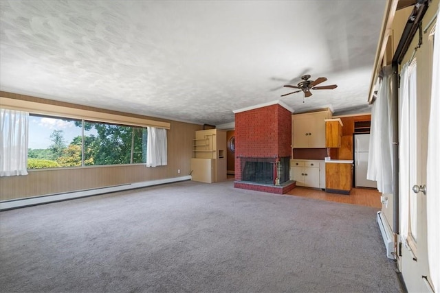 unfurnished living room featuring light carpet, ceiling fan, a fireplace, and a baseboard radiator