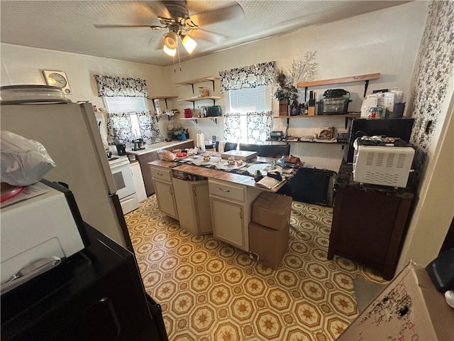 kitchen featuring cream cabinets, ceiling fan, and white range with electric cooktop