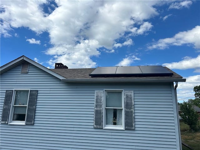 view of side of home with solar panels