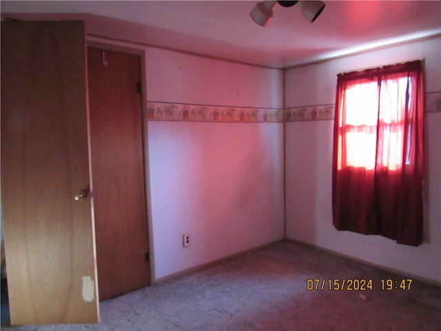 spare room with ceiling fan and light carpet