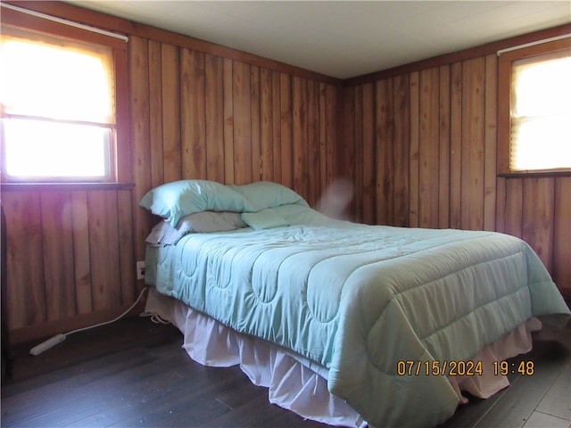 bedroom featuring hardwood / wood-style flooring and wooden walls