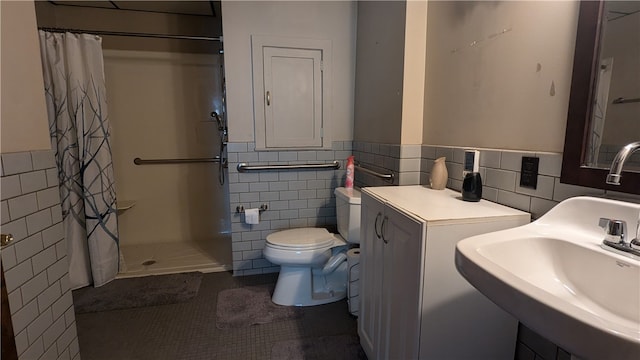 bathroom featuring tile walls, a shower with shower curtain, toilet, sink, and tile patterned floors