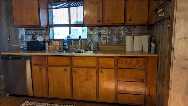 kitchen featuring wood-type flooring, stainless steel dishwasher, sink, and tasteful backsplash