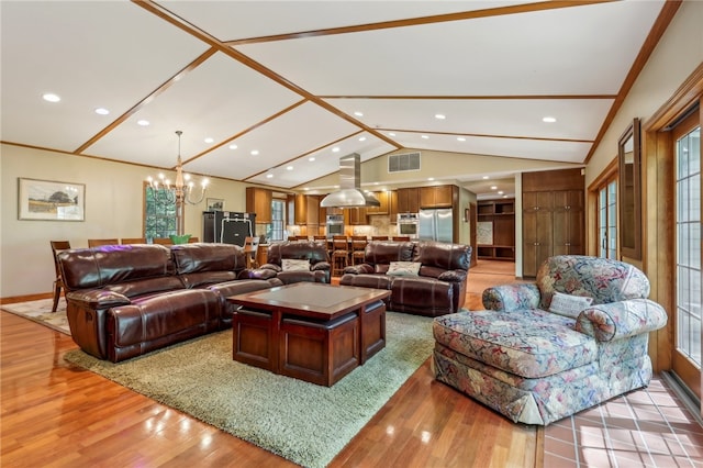 living room featuring lofted ceiling, wood-type flooring, a chandelier, and ornamental molding