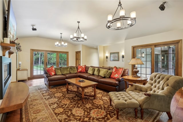 living room with hardwood / wood-style flooring, vaulted ceiling, and a notable chandelier