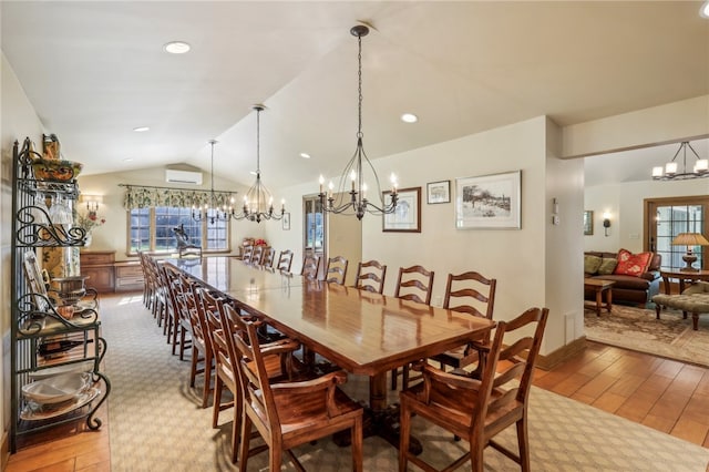 dining room with hardwood / wood-style flooring, lofted ceiling, a wall mounted air conditioner, and an inviting chandelier