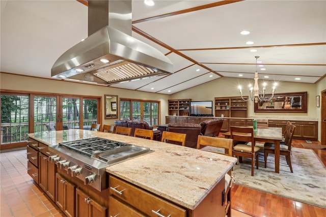 kitchen featuring a chandelier, hanging light fixtures, island exhaust hood, a center island, and vaulted ceiling