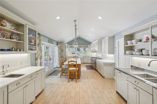 kitchen with sink, lofted ceiling, backsplash, and decorative light fixtures