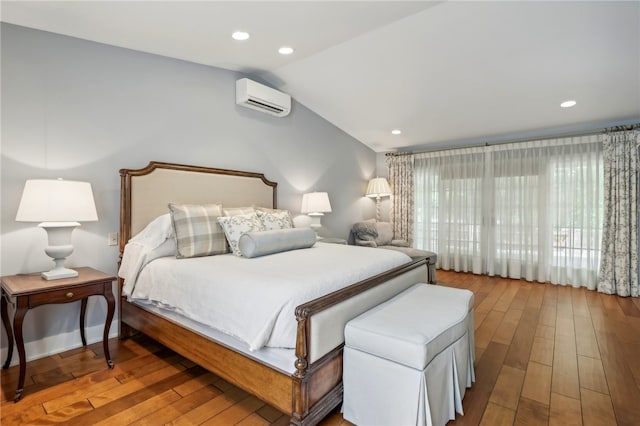 bedroom with a wall mounted air conditioner, hardwood / wood-style floors, and vaulted ceiling