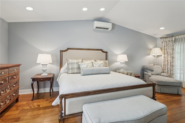 bedroom with a wall mounted AC, lofted ceiling, and hardwood / wood-style floors