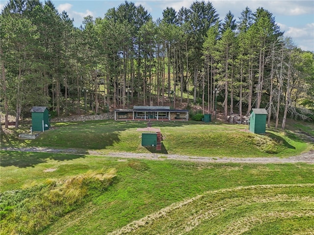 view of property's community featuring a lawn and a storage unit