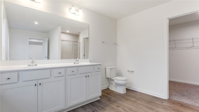 bathroom featuring vanity, hardwood / wood-style flooring, an enclosed shower, and toilet