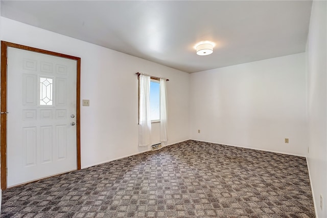 entrance foyer featuring dark colored carpet and a baseboard heating unit