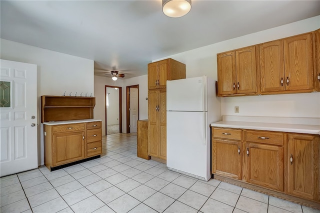 kitchen featuring ceiling fan, white refrigerator, and light tile patterned floors