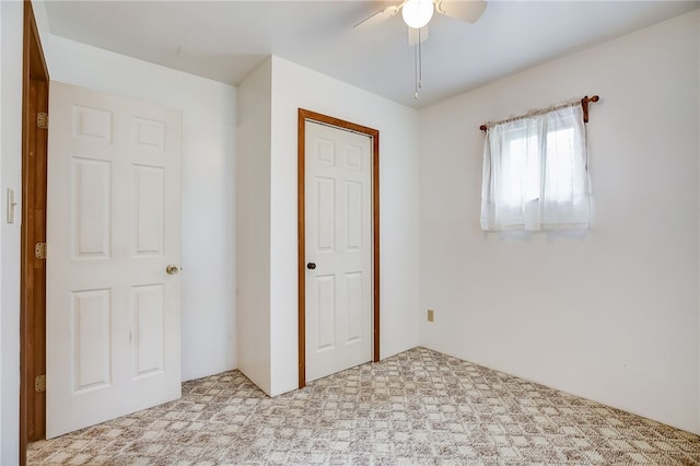 unfurnished bedroom featuring a closet, ceiling fan, and carpet floors