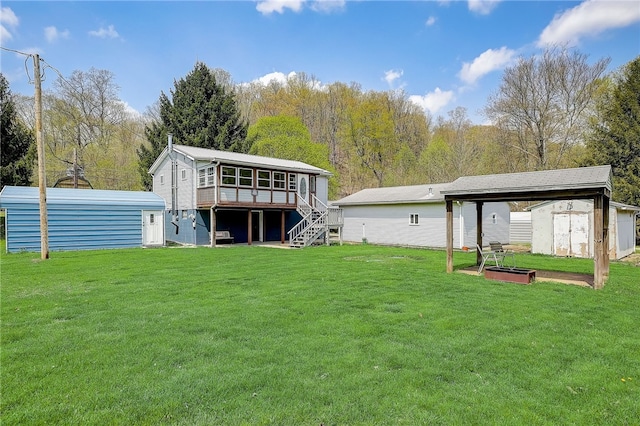 back of house featuring a lawn and an outbuilding