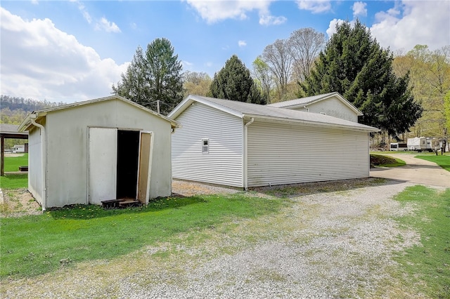 back of property featuring a lawn and a shed