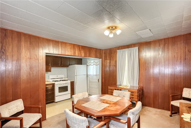 carpeted dining area with wooden walls