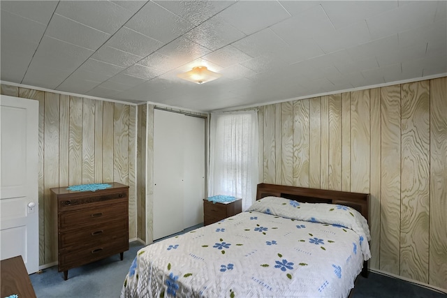 unfurnished bedroom with wood walls and dark carpet