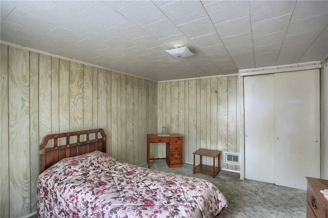 carpeted bedroom with wood walls and a closet