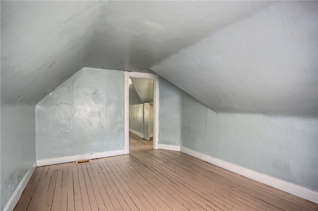 bonus room featuring vaulted ceiling and hardwood / wood-style floors