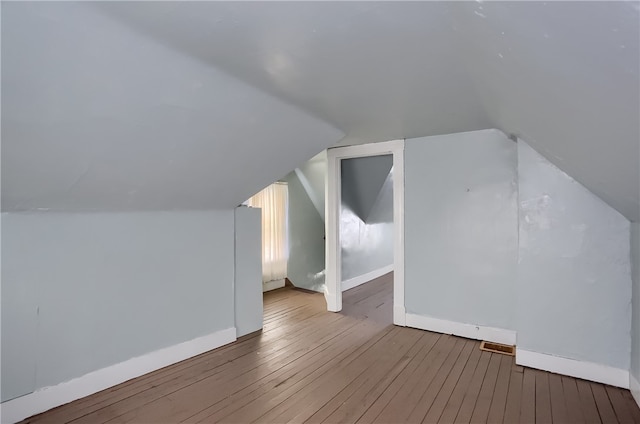 additional living space featuring hardwood / wood-style flooring and vaulted ceiling