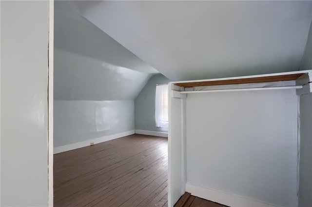 additional living space with hardwood / wood-style flooring and vaulted ceiling