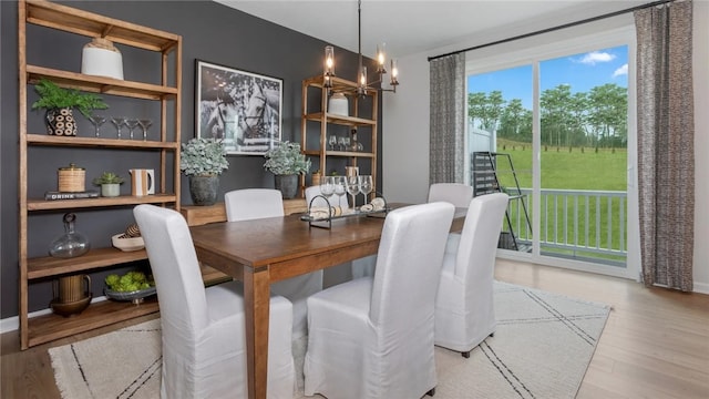 dining space featuring light hardwood / wood-style floors and an inviting chandelier