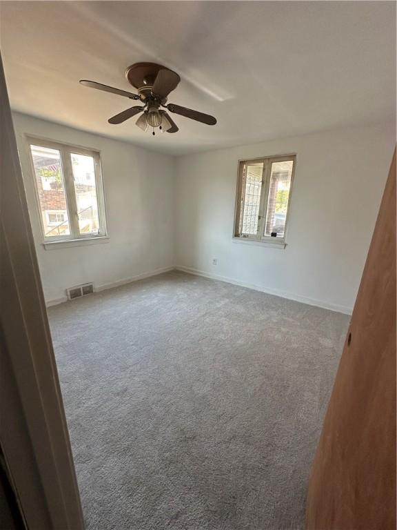 unfurnished room with carpet floors and ceiling fan