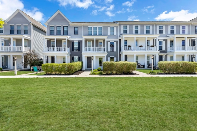 view of front of home featuring a balcony and a front lawn