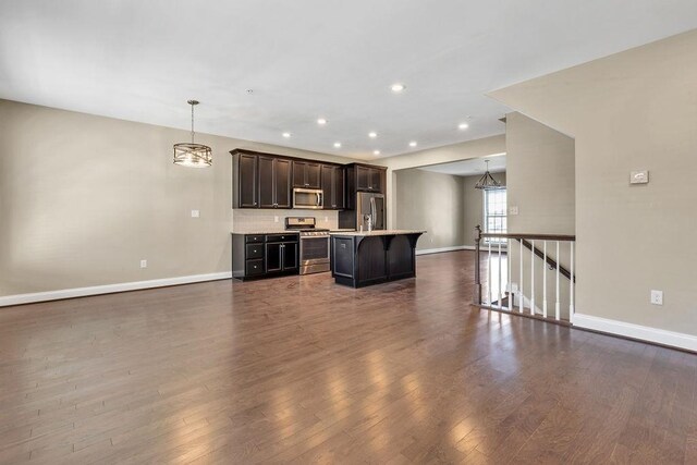 unfurnished living room featuring dark hardwood / wood-style flooring and a chandelier