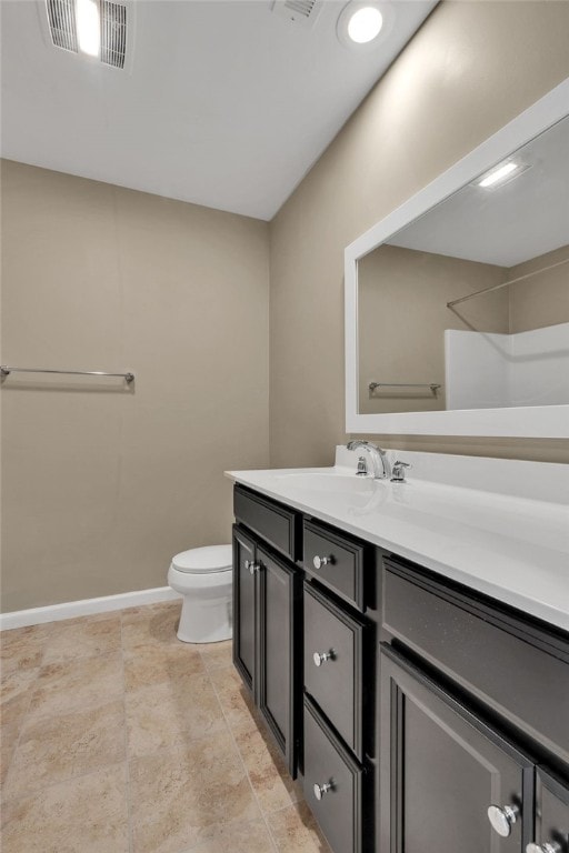 bathroom featuring tile patterned flooring, toilet, and vanity