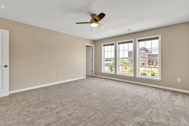 carpeted spare room with ceiling fan