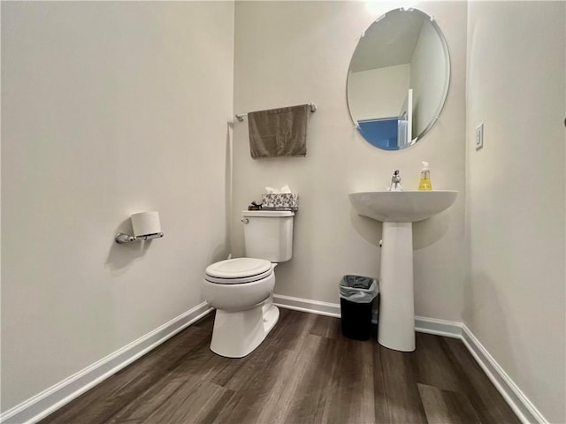 bathroom with hardwood / wood-style flooring, toilet, and sink