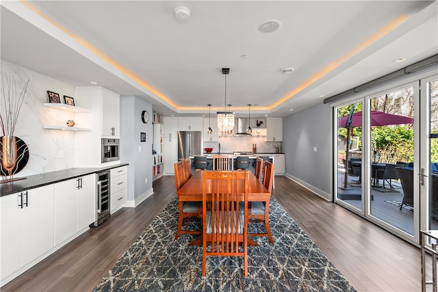 dining room with wine cooler, dark hardwood / wood-style floors, and a tray ceiling