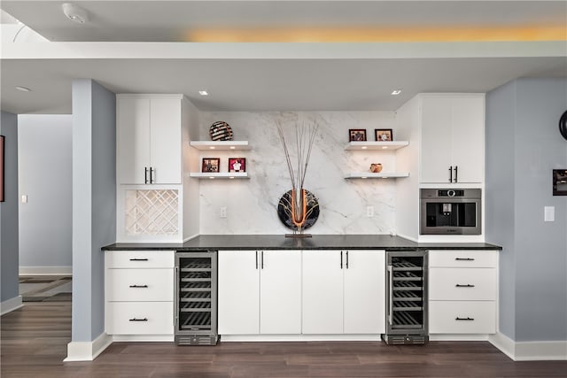 bar featuring dark hardwood / wood-style floors, backsplash, wall oven, and wine cooler