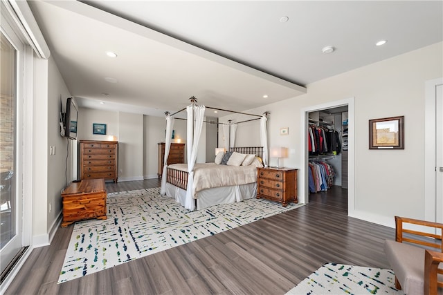 bedroom featuring dark hardwood / wood-style floors, a walk in closet, and a closet