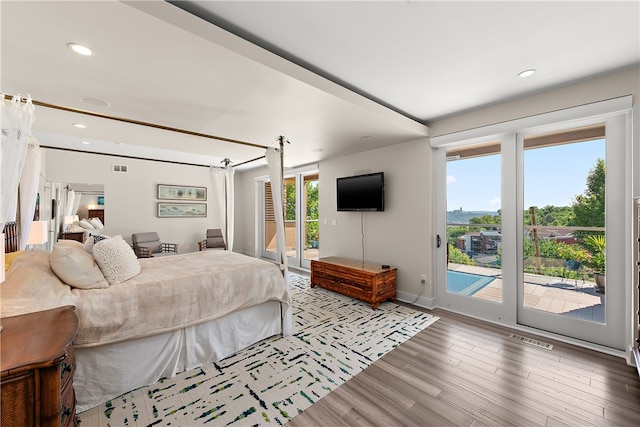 bedroom featuring access to exterior and hardwood / wood-style floors