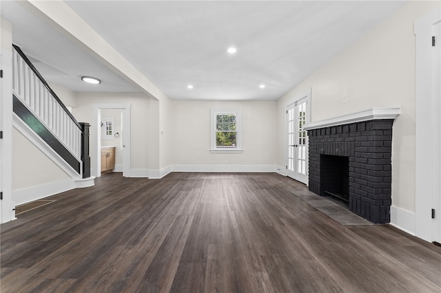 unfurnished living room featuring a fireplace and dark wood-type flooring